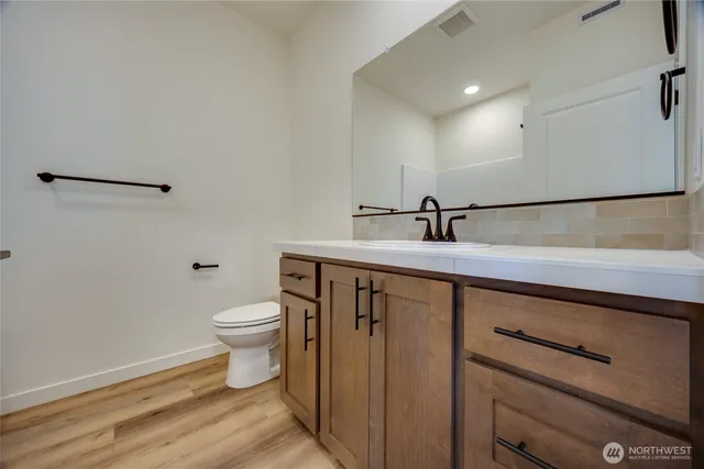 a bathroom with a sink a toilet and mirror
