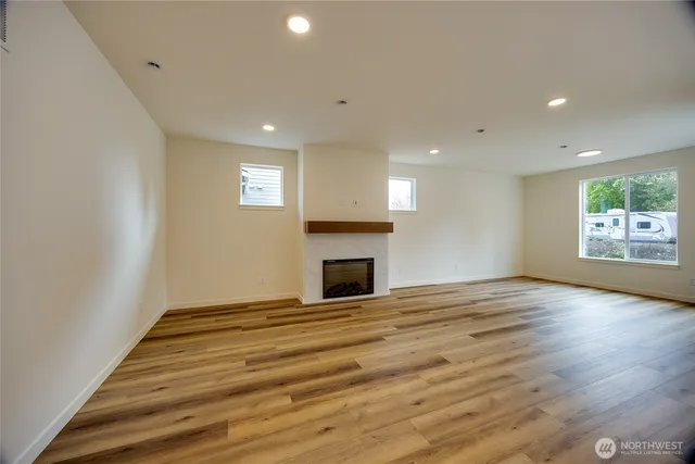 a view of empty room with wooden floor and fireplace