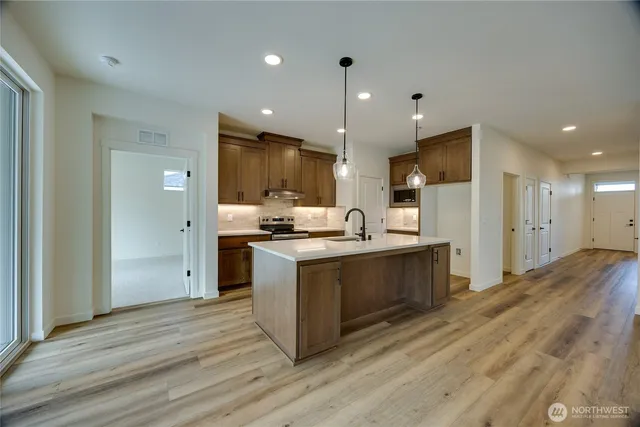 a kitchen with stainless steel appliances kitchen island wooden cabinets and granite counter tops