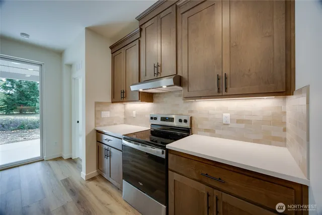 a kitchen with stainless steel appliances granite countertop a sink a stove and a refrigerator