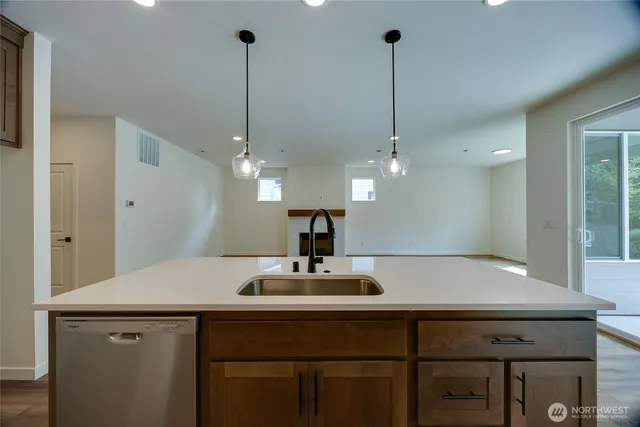 a kitchen with a sink chandelier and wooden floor