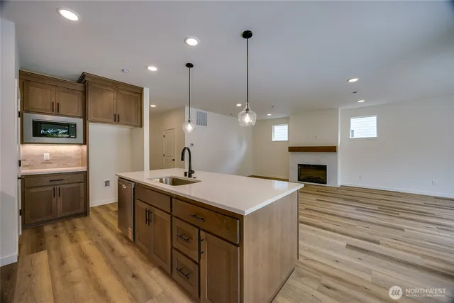 a kitchen with cabinets wooden floor and stainless steel appliances