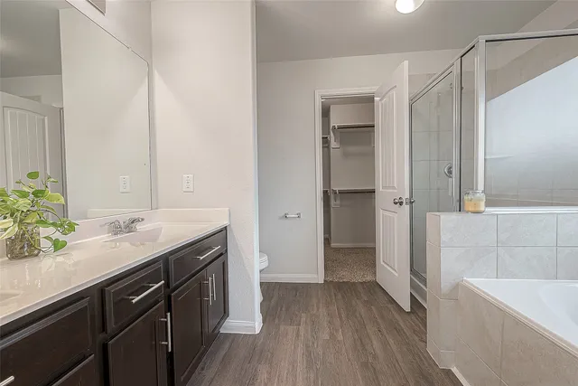 a bathroom with a granite countertop sink a toilet and shower