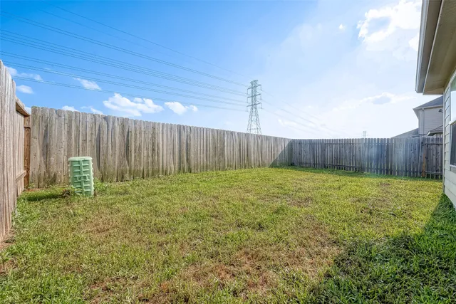 a view of a backyard with potted plants and wooden fence