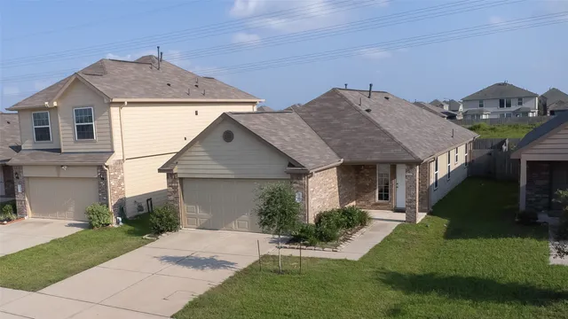 a aerial view of a house next to a yard