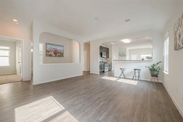 a view of a livingroom with furniture wooden floor and a kitchen