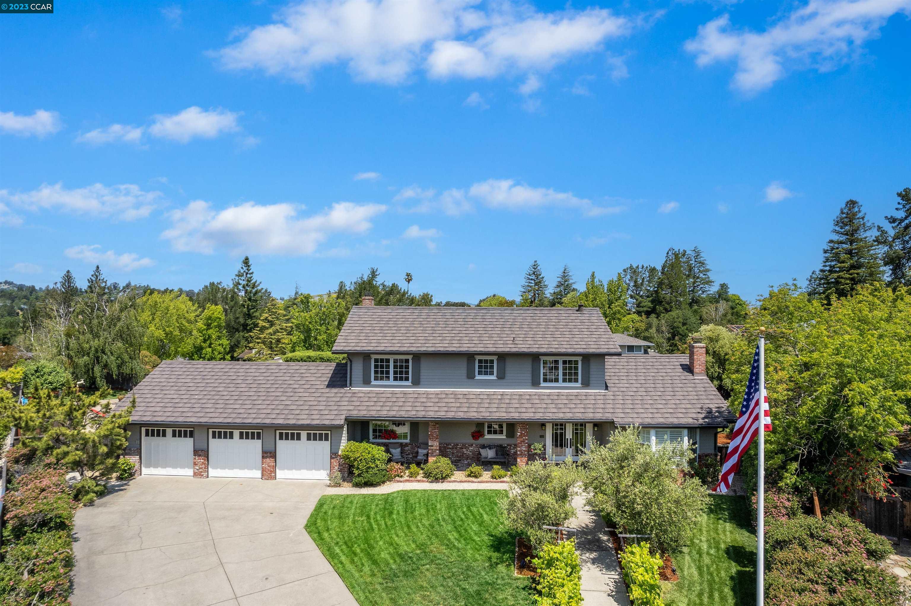a view of a white house with a yard and potted plants