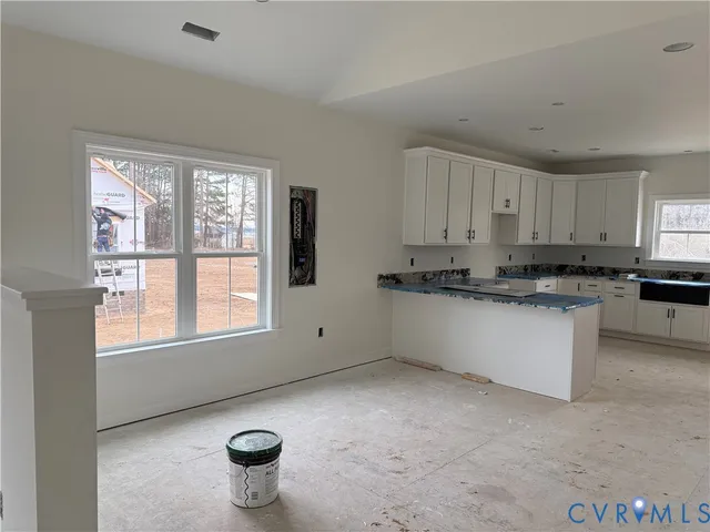 a kitchen with granite countertop white cabinets and stainless steel appliances