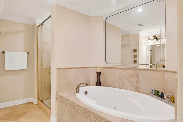 a bedroom with a large bed and a chandelier