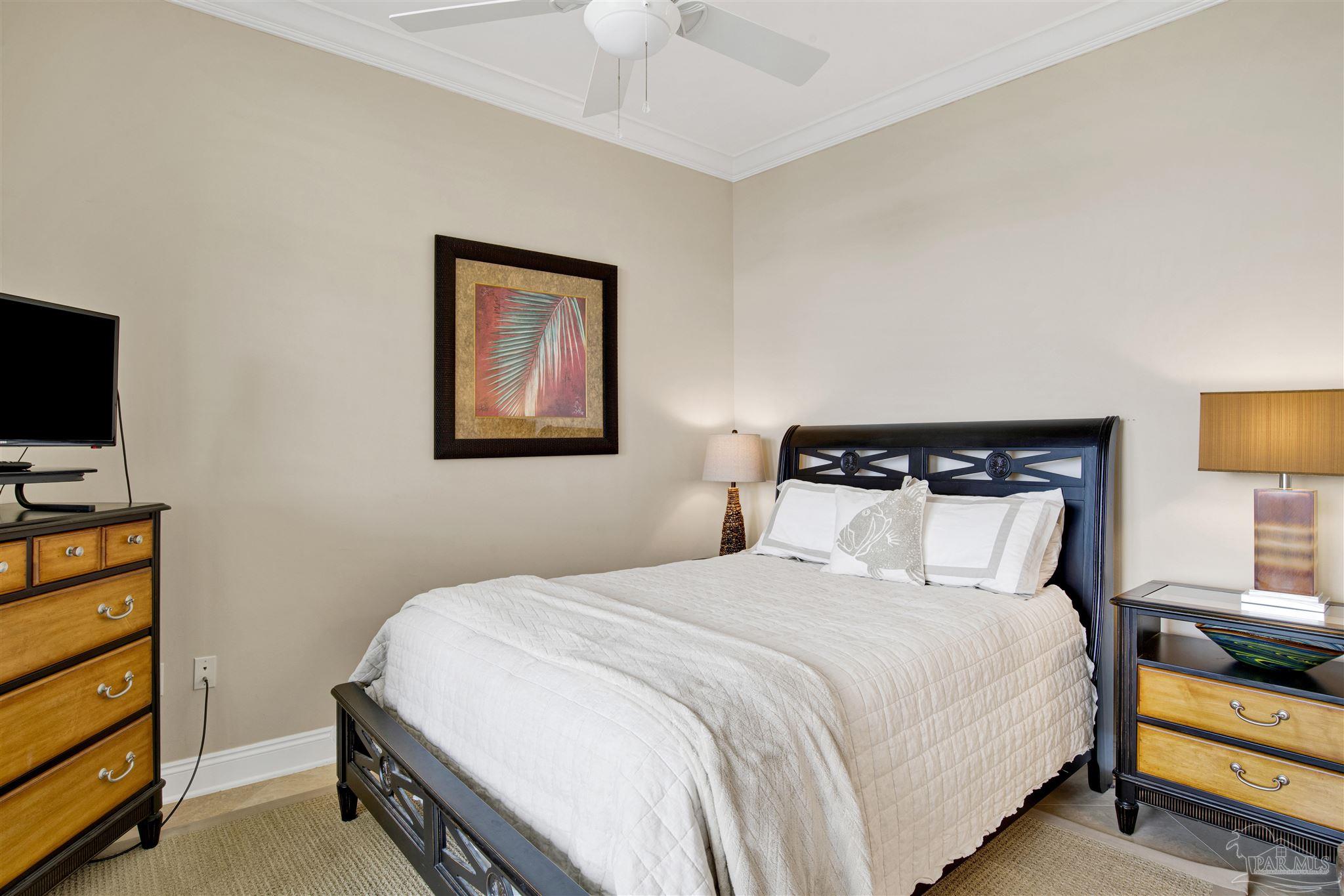 16547 Perdido Key Drive, Unit E501 Pensacola, FL 32507 - Photo 32 of 63 a bedroom with a bed and a tv on the dresser