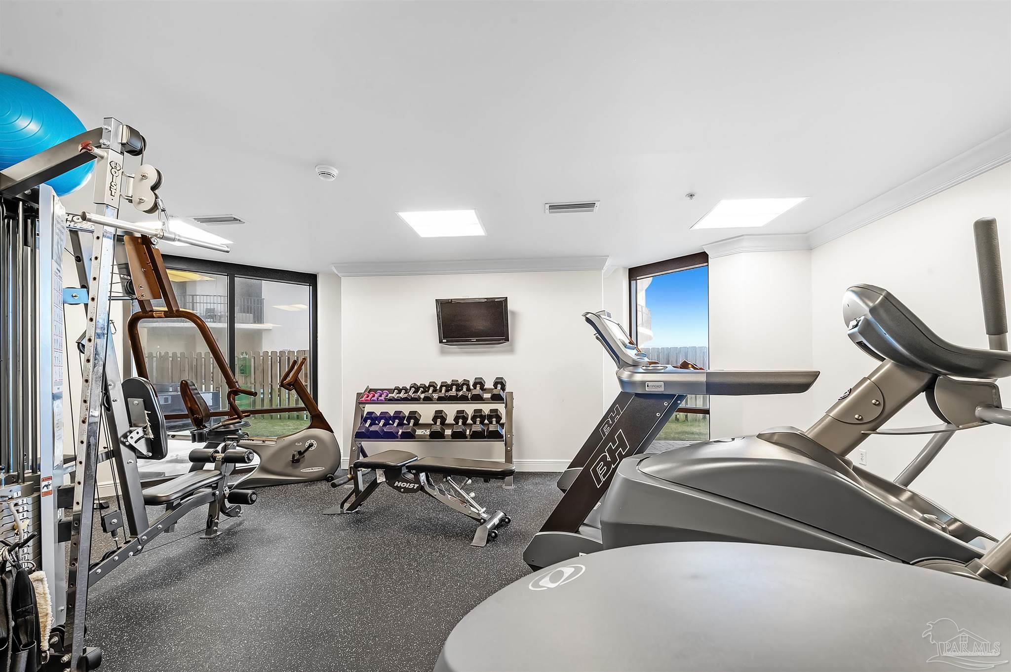 16547 Perdido Key Drive, Unit E501 Pensacola, FL 32507 - Photo 41 of 63 a room with gym equipment and a flat screen tv