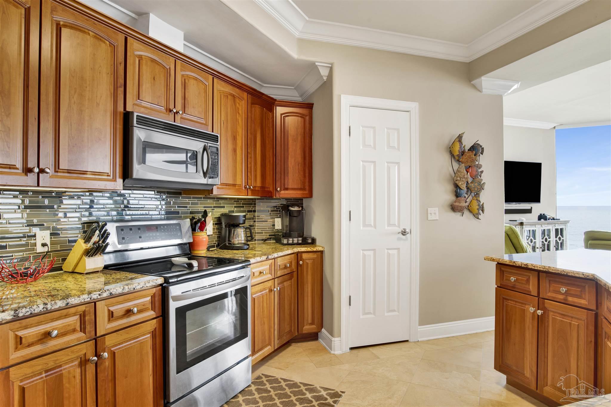 16547 Perdido Key Drive, Unit E501 Pensacola, FL 32507 - Photo 7 of 63 a kitchen with stainless steel appliances granite countertop a stove a sink dishwasher and a microwave oven with cabinets