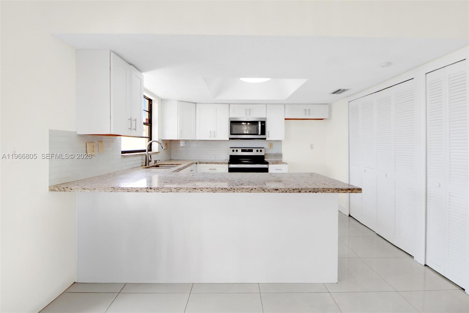 13844 Southwest 15th Street Miami, FL 33184 - Photo 22 of 31 a kitchen with kitchen island granite countertop a sink a stove top oven a counter top space and cabinets