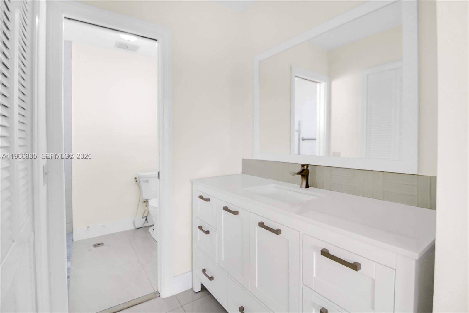 13844 Southwest 15th Street Miami, FL 33184 - Photo 9 of 31 a bathroom with a sink and a mirror