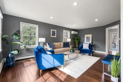 a living room with furniture and a wooden floor
