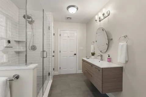 a bathroom with a double vanity sink mirror and shower