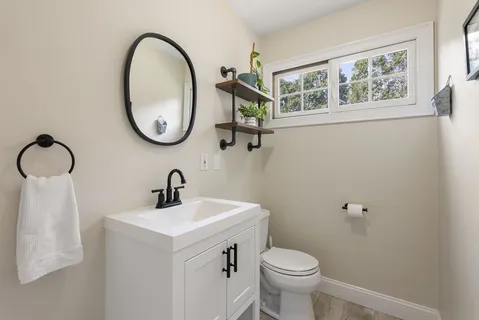 a bathroom with a toilet sink and mirror