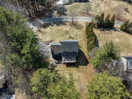 an aerial view of a house with a yard and large trees