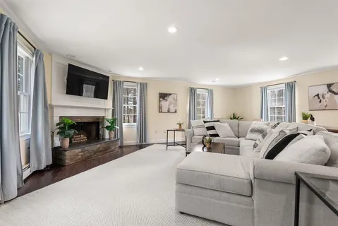 a living room with furniture a fireplace and a flat screen tv
