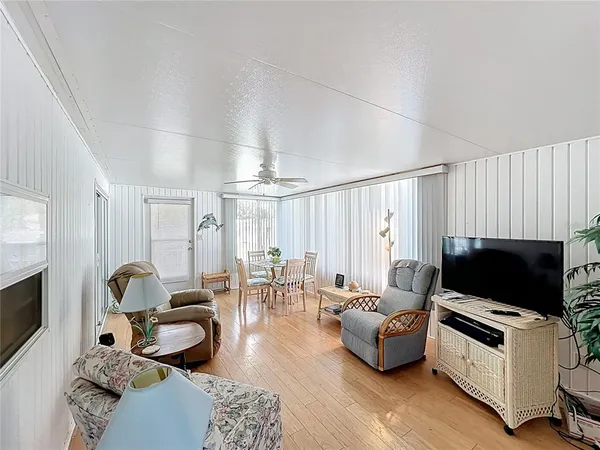 a living room with furniture a flat screen tv and a window