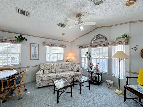 a living room with furniture a chandelier and a window