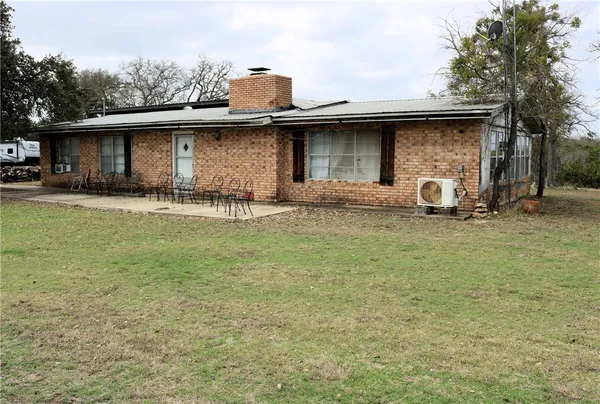 a view of a house with backyard and sitting area