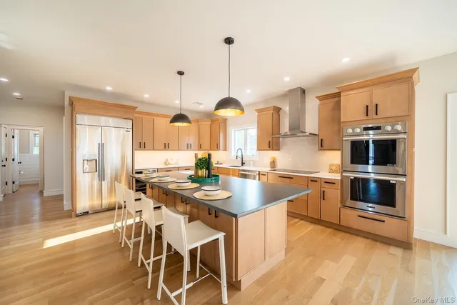 a kitchen with stainless steel appliances kitchen island wooden floors and white cabinets