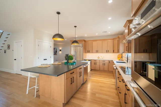 a kitchen with stainless steel appliances kitchen island granite countertop a stove a sink and a refrigerator
