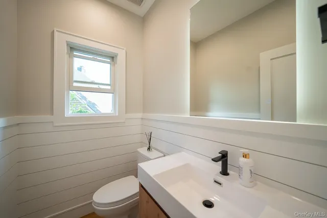 a bathroom with a sink a toilet and window