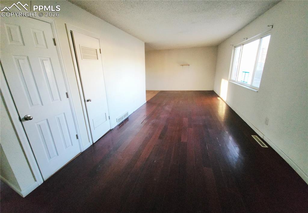 1214 Burnham Street Colorado Springs, CO 80906 - Photo 4 of 11 an empty room with wooden floor and windows