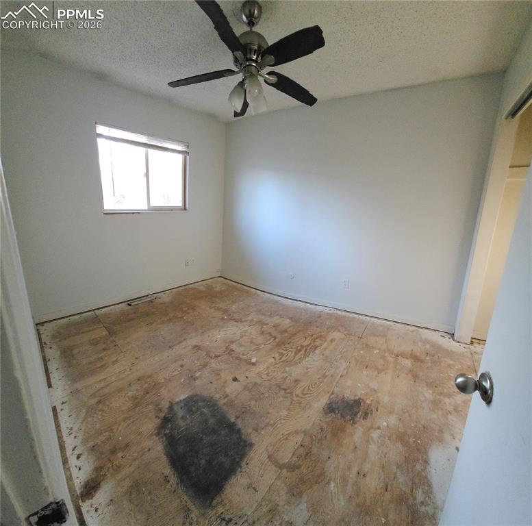 1214 Burnham Street Colorado Springs, CO 80906 - Photo 7 of 11 an empty room with a window and a ceiling fan