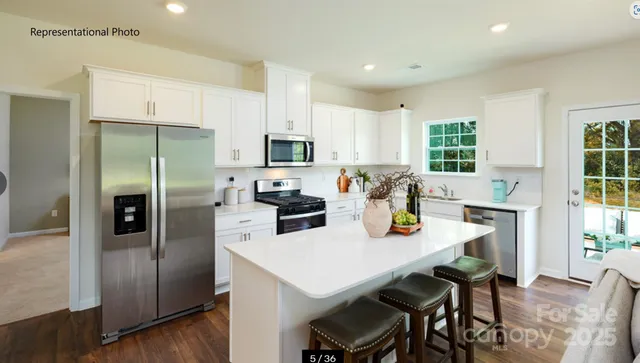 a kitchen with a refrigerator a stove a sink and a dining table