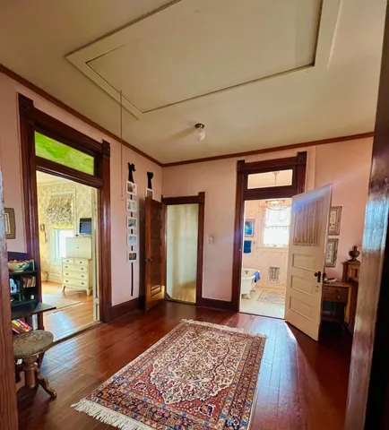 a view of a hallway to a livingroom with furniture