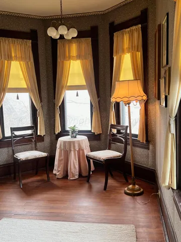 a view of a hallway with wooden floor and a chandelier