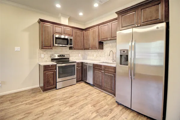 a kitchen with stainless steel appliances granite countertop a refrigerator stove and microwave