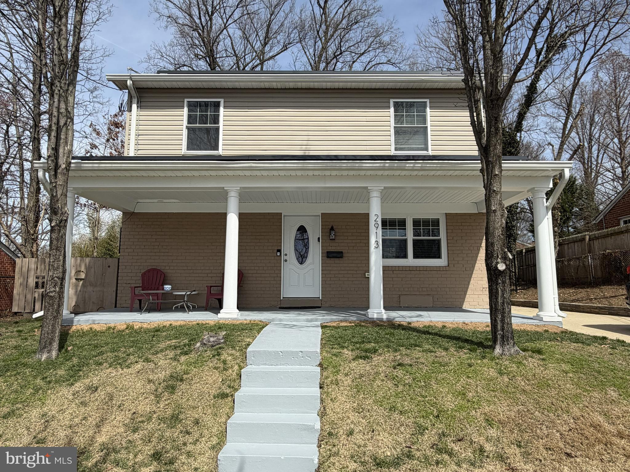a view of a house with a yard and large tree