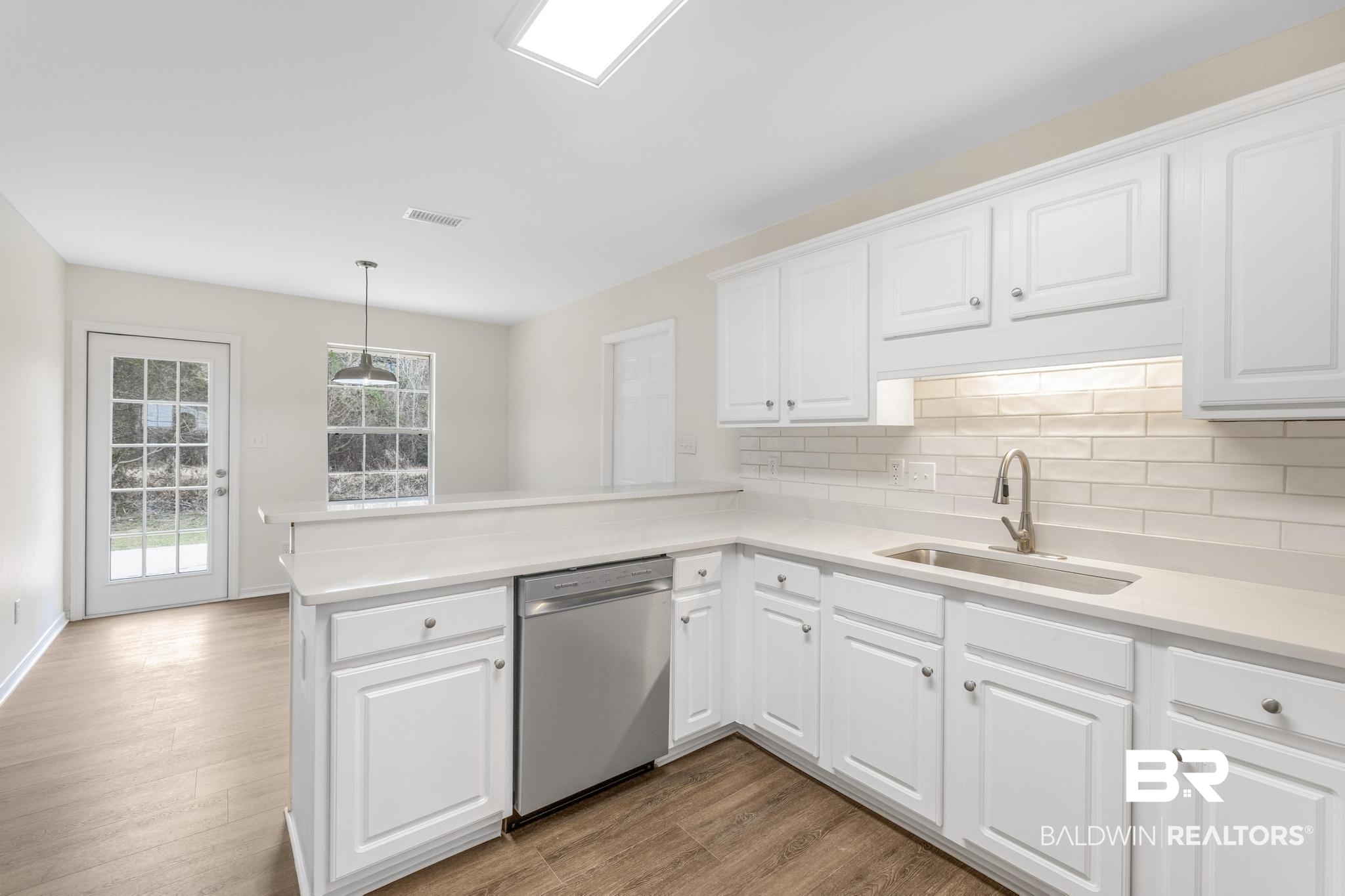 16330 Absalom Street Foley, AL 36535 - Photo 20 of 42 Kitchen with pendant lighting, white cabinetry, dishwasher, sink, and kitchen peninsula