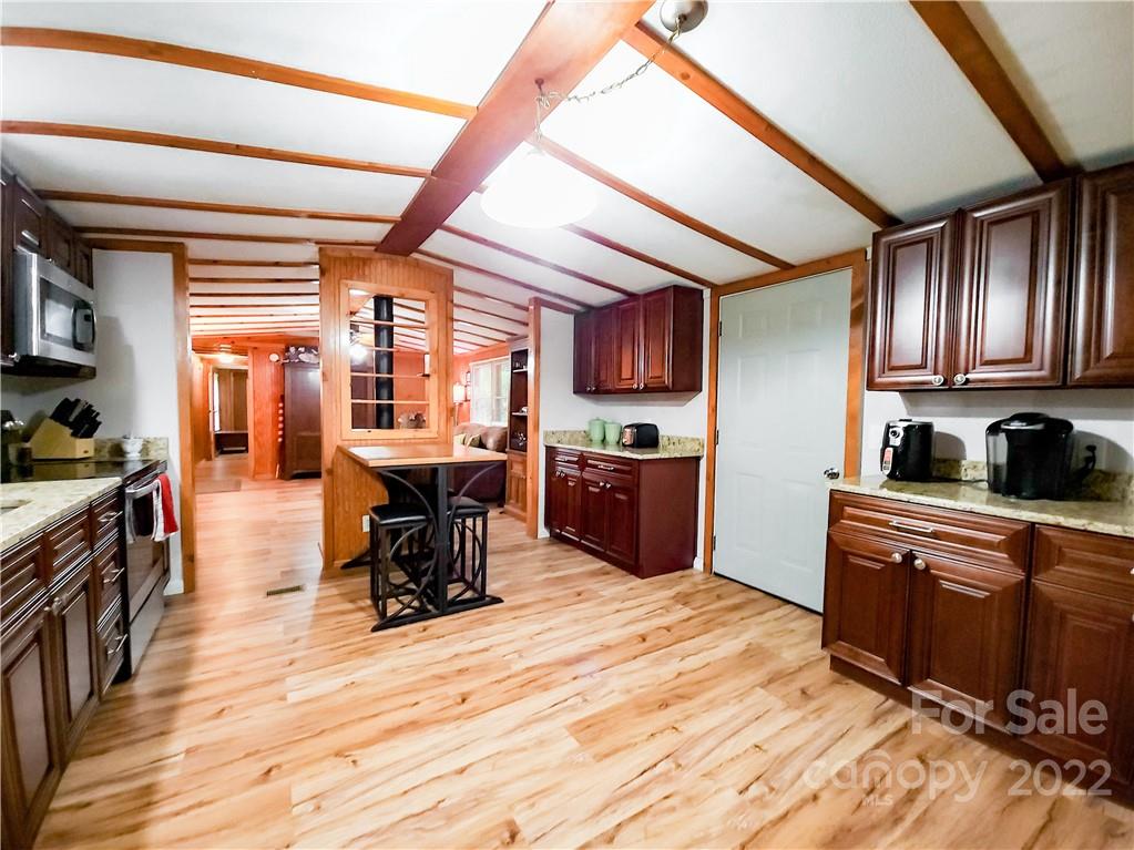 278 Pipers Neck Rutherfordton, NC 28139 - Photo 14 of 42 a kitchen with stainless steel appliances kitchen island granite countertop a stove top oven a sink dishwasher a dining table and chairs with wooden floor