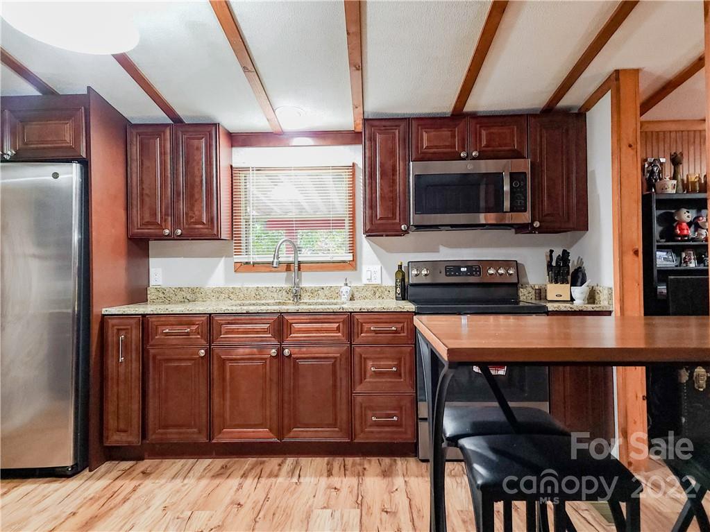 278 Pipers Neck Rutherfordton, NC 28139 - Photo 16 of 42 a kitchen with stainless steel appliances wooden cabinets a stove a sink and a refrigerator