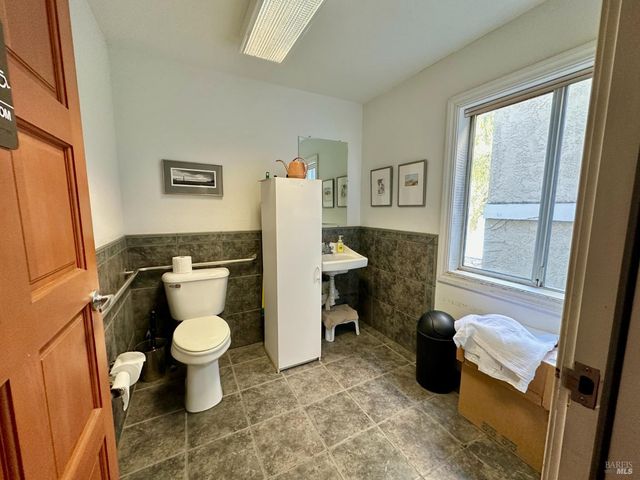 a spacious bathroom with a granite countertop sink and a toilet