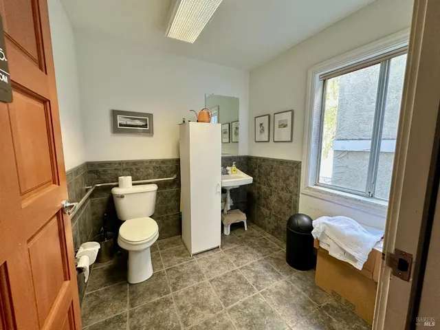 a spacious bathroom with a granite countertop sink and a toilet
