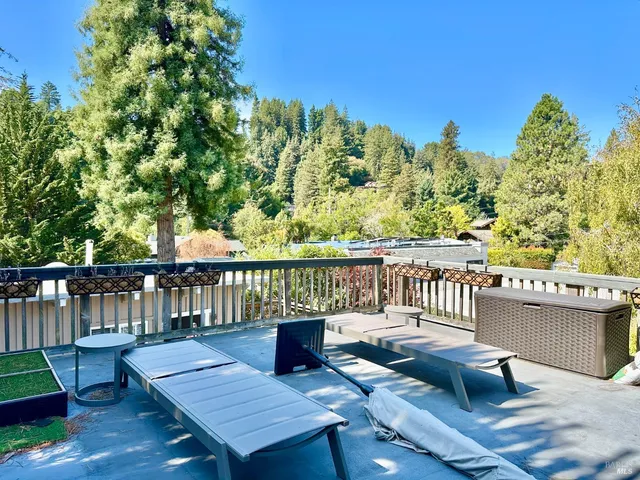 a view of a balcony with wooden floor and outdoor seating