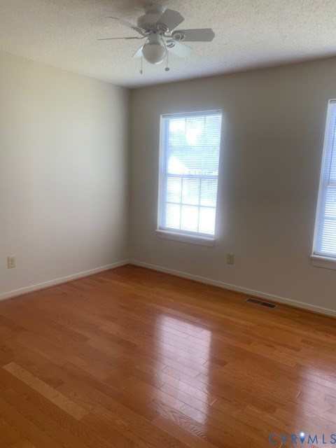 4100 Montclair Road Richmond, VA 23223 - Photo 4 of 8 an empty room with wooden floor chandelier fan and windows