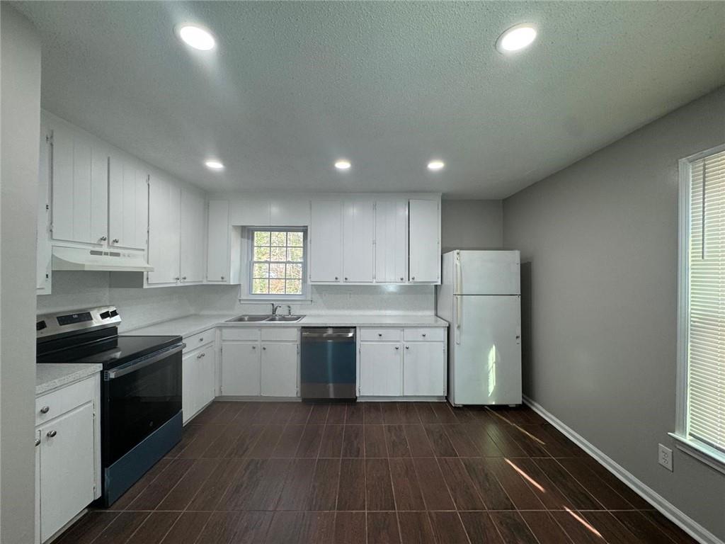 385 Holly Ridge Drive Northwest, Unit 5 Lilburn, GA 30047 - Photo 2 of 10 a kitchen with refrigerator and cabinets