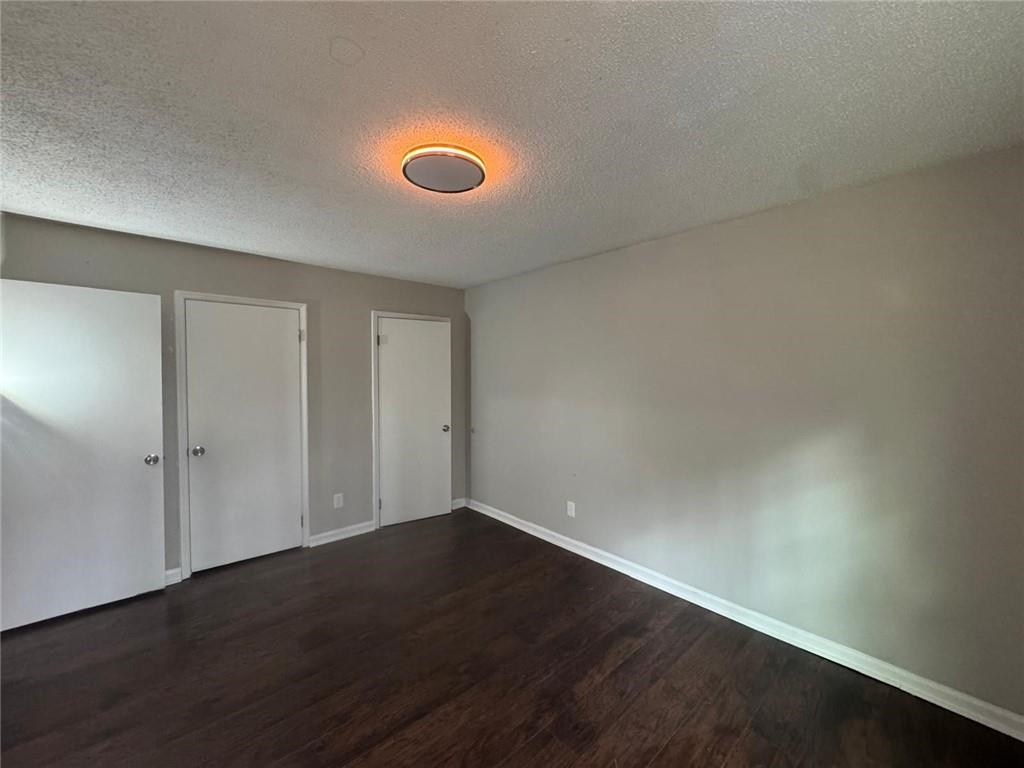 385 Holly Ridge Drive Northwest, Unit 5 Lilburn, GA 30047 - Photo 8 of 10 an empty room with wooden floor and windows