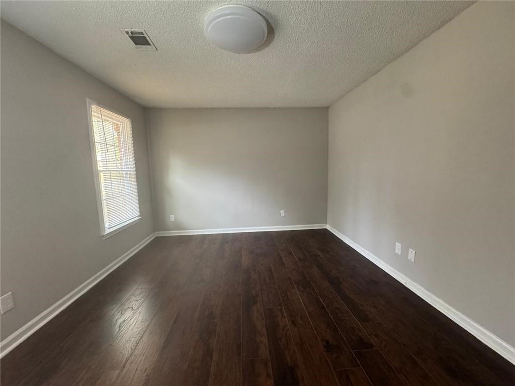 385 Holly Ridge Drive Northwest, Unit 5 Lilburn, GA 30047 - Photo 9 of 10 an empty room with wooden floor and windows