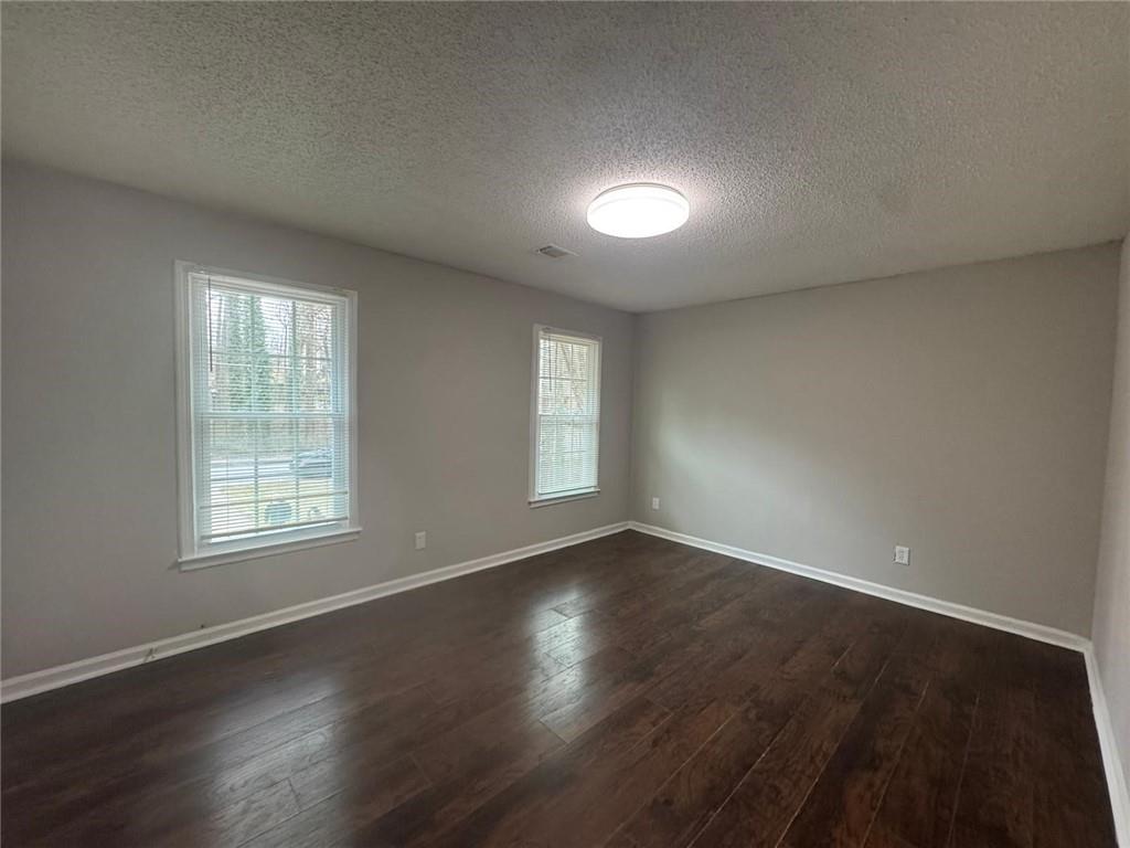 385 Holly Ridge Drive Northwest, Unit 5 Lilburn, GA 30047 - Photo 10 of 10 an empty room with wooden floor and windows