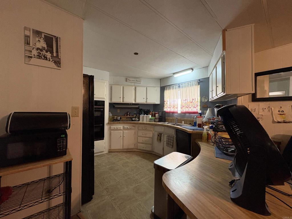 15420 Olde Highway 80 El Cajon, CA 92021 - Photo 29 of 48 a kitchen with a table chairs refrigerator and microwave