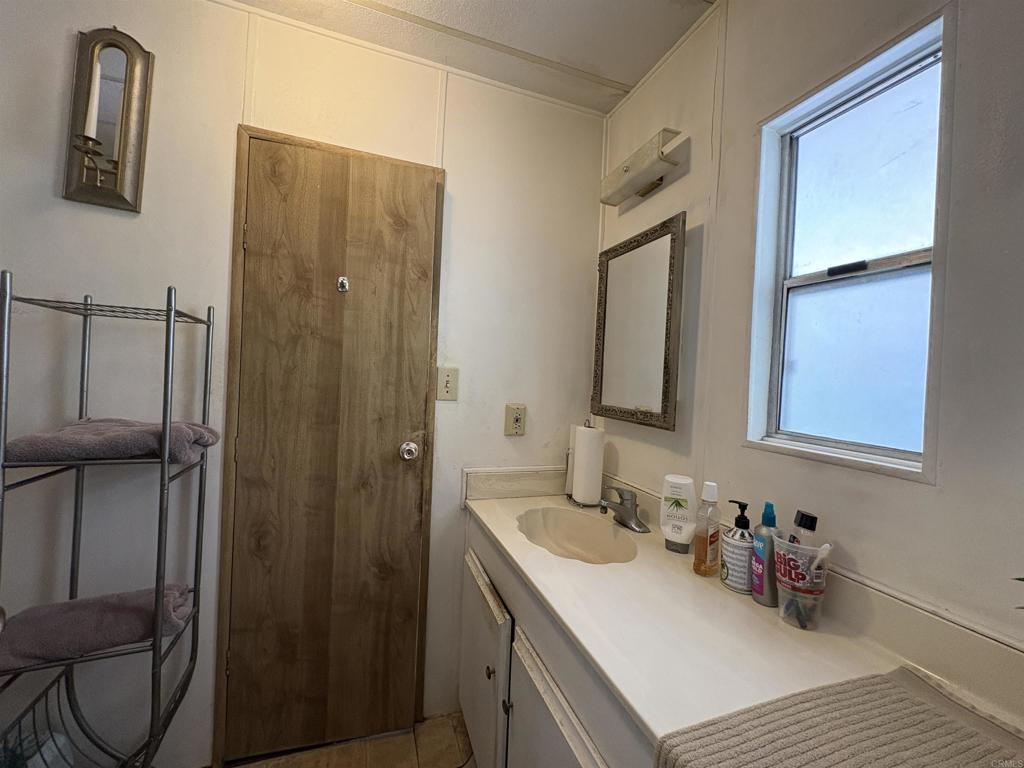 15420 Olde Highway 80 El Cajon, CA 92021 - Photo 47 of 48 a bathroom with a sink vanity and mirror