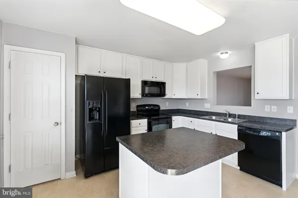 a kitchen with stainless steel appliances granite countertop a refrigerator a sink a stove a microwave and wooden cabinets